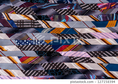 Patchwork Blanket. A fragment of colorful pieces of fabric sewn together. 127158394