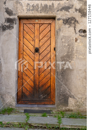 Old Wooden Door on Weathered Stone Wall 127158446