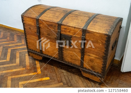 Wooden chest of drawers stands on an old wooden parquet floor. Wooden chest of drawers stands on an old wooden parquet floor. 127158460