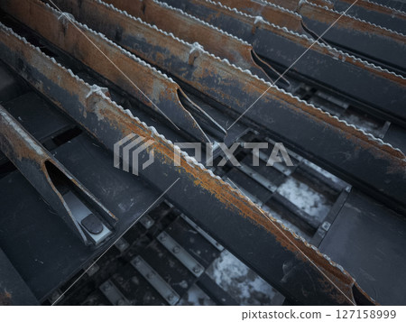 Close up of rusty metal structures with serrated edges, industrial decay and texture in aosta, italy during november Close up of rusty metal structures with serrated edges, industrial decay and texture in aosta, italy during november 127158999