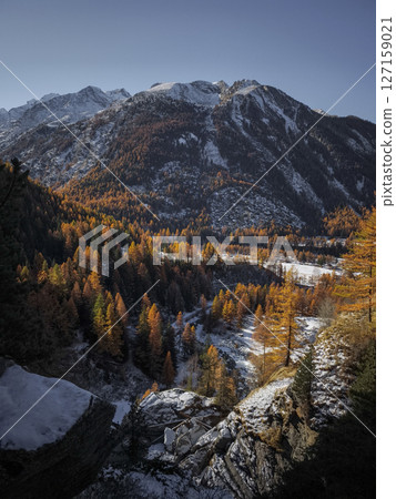 Snow dusted peaks of the italian alps rising above a vibrant larch forest in the aosta valley during autumn's transition to winter Cascate di Lillaz Snow dusted peaks of the italian alps rising above a vibrant larch forest in the aosta valley during autumn's transition to winter Cascate di Lillaz 127159021