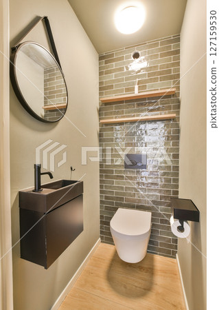 A sleek and contemporary bathroom featuring elegant fixtures and a minimalist aesthetic. The design highlights the interplay of materials and light. 127159530