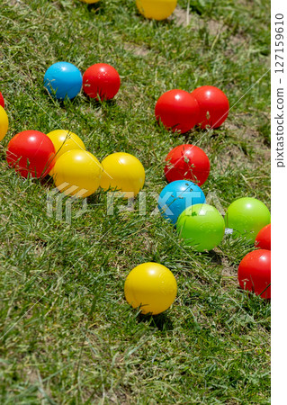 Multi colored balls on the green grass Multi colored balls on the green grass 127159610