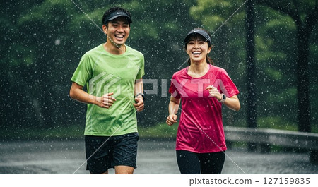Male and female runners running energetically even on rainy days 127159835