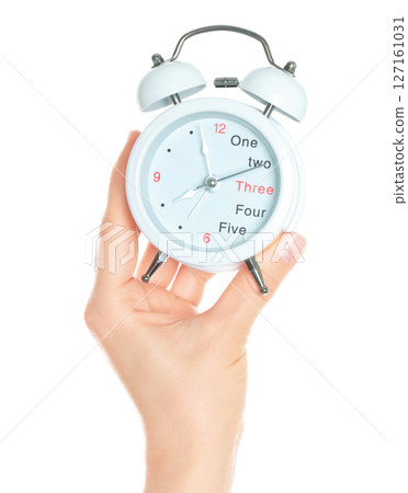 Woman hand holds white Alarm Clock, isolated on transparent background, time and home things concept 127161031