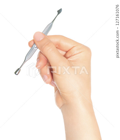 Woman hand holds manicure pusher, isolated on transparent background, cosmetic tools concept 127161076