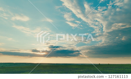 A Serene Landscape at Dusk Featuring an Expansive Sky with Beautiful Clouds Present 127161113