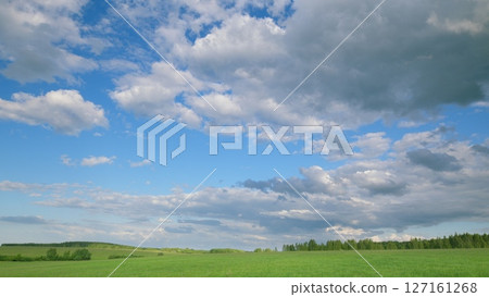 A Vibrant Cloudy Sky Over a Beautiful Green Meadow Landscape That Captivates Natures Essence 127161268