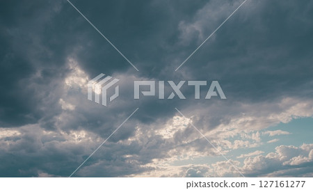 A Dramatic and Cloudy Sky with Sunlight Beautifully Peeking Through the Clouds above A Dramatic and Cloudy Sky with Sunlight Beautifully Peeking Through the Clouds above 127161277