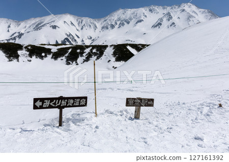 陽光明媚的日子，立山上指向室堂站和禦庫裡池溫泉的積雪路標 127161392