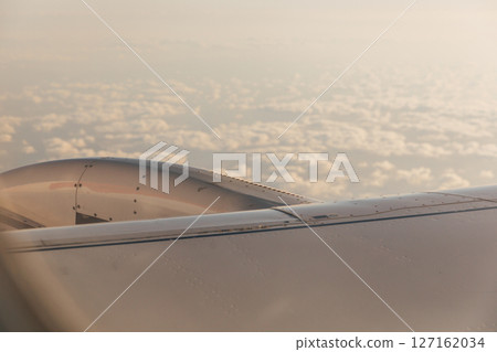 A wing of a passenger plane and clouds at sunset A wing of a passenger plane and clouds at sunset 127162034