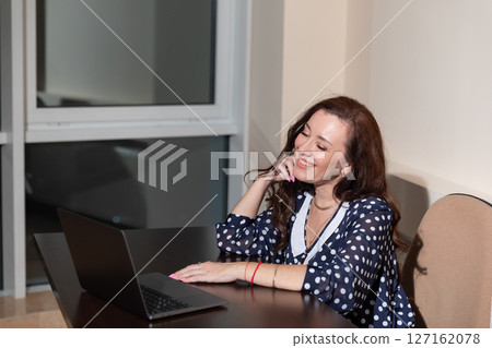 woman working on laptop online at desk in office woman working on laptop online at desk in office 127162078