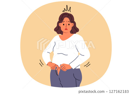 Overweight woman cannot fit into old jeans due to excess weight caused by overeating 127162183
