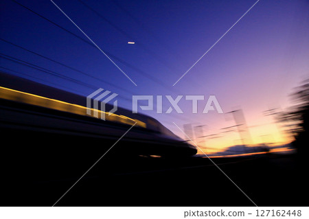 A bullet train speeds off with the western sky at its back A bullet train speeds off with the western sky at its back 127162448