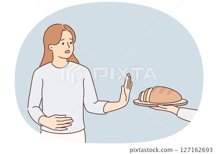 Frustrated woman holding on to stomach refuses bread due to allergies and gluten intolerance 127162693