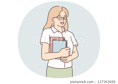 Young girl student stands with books in hands posing with glasses and looking at screen 127162699