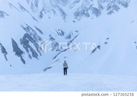 A tranquil scene capturing a person walking alone on the snowy mountain of Mt. Tateyama early in the morning before sunrise. A tranquil scene capturing a person walking alone on the snowy mountain of Mt. Tateyama early in the morning before sunrise. 127163238