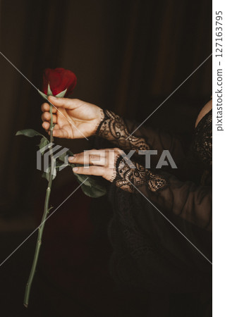 Elegant Hands Delicately Holding a Red Rose 127163795