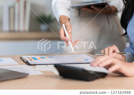 Data Analysis Collaboration. Professionals discussing project details and insights in modern office. Data Analysis Collaboration. Professionals discussing project details and insights in modern office. 127163998