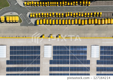 Delivery vans hub with solar panel on a roof. Fleet of yellow post vehicles Delivery vans hub with solar panel on a roof. Fleet of yellow post vehicles 127164214