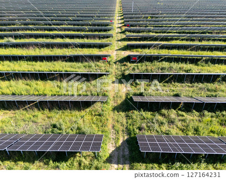 Aerial view of solar power station on a green field. Sustainable development. 127164231