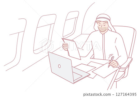 A Businessman Engaged in Work on His Laptop While Traveling on an Airplane High Above 127164395
