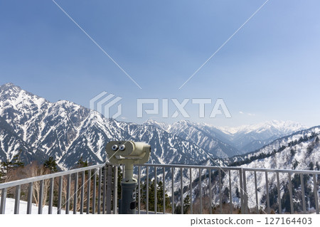 Binoculars and snowy mountain view at Kurobedaira Terrace 127164403