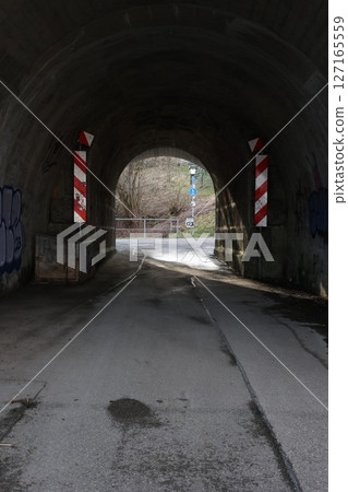 Tunnel with graffiti on the walls and a red and white sign Tunnel with graffiti on the walls and a red and white sign 127165559