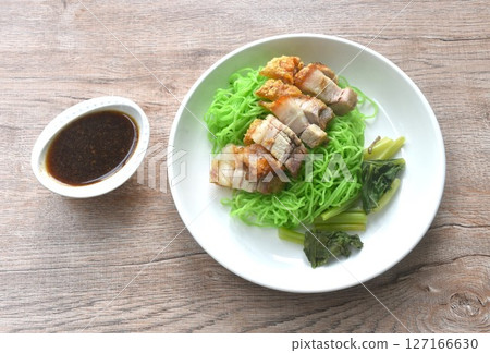Chinese jade noodles topping roasted crispy pork dipping sweet soy sauce on plate Chinese jade noodles topping roasted crispy pork dipping sweet soy sauce on plate 127166630