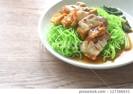 Chinese jade noodles topping roasted crispy pork dipping sweet soy sauce on plate  127166631