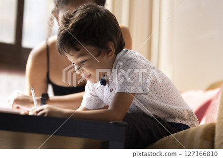Preschooler boy doing homework with his mother at home 127166810