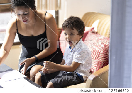 Excited child playing while mother works from home 127166820