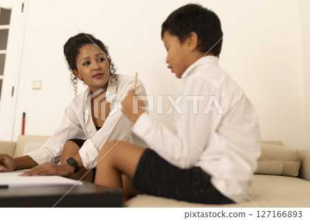 Mother helping son with homework, supporting education at home Mother helping son with homework, supporting education at home 127166893