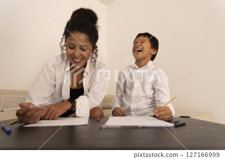 Mother and son drawing and laughing together at home 127166999