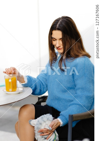 Businesswoman petting her chihuahua dog at outdoor cafe 127167606