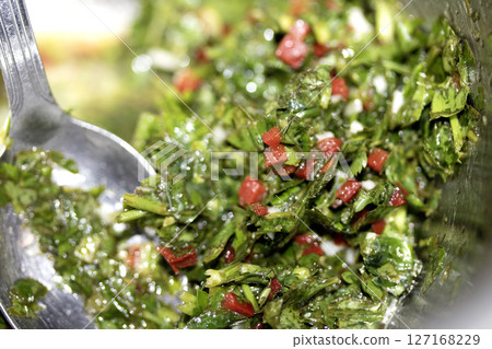 Close up of chimichurri sauce marinade with spoon in a bowl healthy Close up of chimichurri sauce marinade with spoon in a bowl healthy 127168229