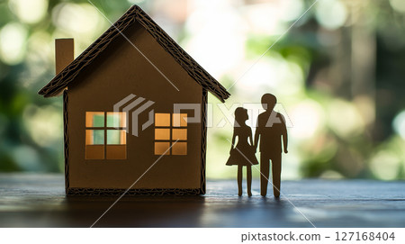 Cardboard house with paper cut-out people figures for family concept. 127168404
