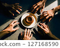 Several hands eagerly reach for a delicious chocolate donut centered on a plate, portraying concepts of shared desire, temptation, and the pursuit of indulgence 127168590