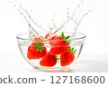 Vibrant red strawberries create a refreshing water splash in a clear glass bowl, symbolizing freshness, healthy food, and natural hydration, with ample copy space 127168600