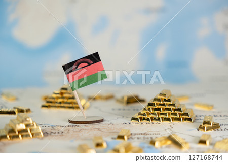 Malawi flag stands amidst numerous shiny gold bars on a blurred world map, symbolizing national wealth, resources, and global investment Malawi flag stands amidst numerous shiny gold bars on a blurred world map, symbolizing national wealth, resources, and global investment 127168744