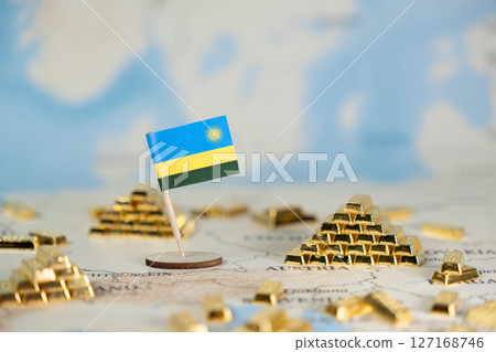 Rwanda national flag standing on a global map surrounded by miniature gold bars, symbolizing economic potential and national wealth 127168746