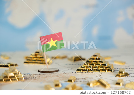 Burkina Faso flag and abundant gleaming gold bars on a world map, symbolizing national wealth, resource potential, and global economy with copy space 127168762