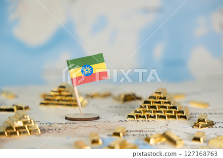 Ethiopian flag proudly stands on a world map surrounded by shining gold bars, symbolizing national wealth, economic potential, and global investment with copy space Ethiopian flag proudly stands on a world map surrounded by shining gold bars, symbolizing national wealth, economic potential, and global investment with copy space 127168763