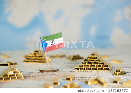 Equatorial Guinea flag stands on a world map with numerous gold bars, symbolizing national wealth, resource management, and global economic investment opportunities, with ample copy space 127168772