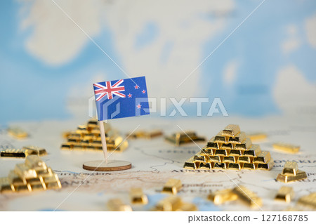 New Zealand flag stands on a world map surrounded by miniature gold bars, symbolizing national wealth, global finance, and investment potential New Zealand flag stands on a world map surrounded by miniature gold bars, symbolizing national wealth, global finance, and investment potential 127168785