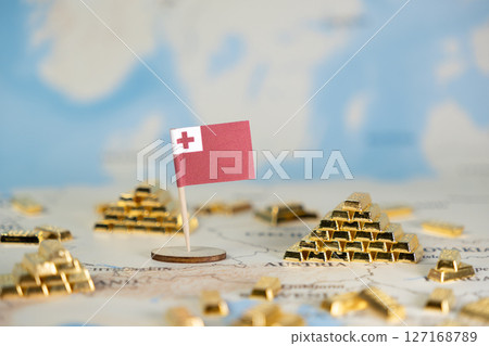 Tonga flag with gleaming gold bars arranged on a world map, symbolizing national economic wealth, global trade, and investment opportunities with ample copy space 127168789