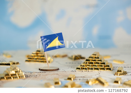 Tokelau flag on a world map with shining gold bar pyramids, symbolizing national wealth, global investment, and economic stability with copy space 127168792