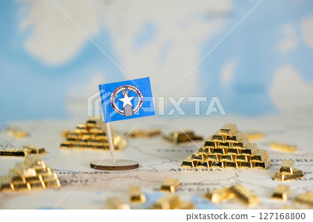 Northern Mariana Islands national flag prominently placed on a global map surrounded by shining gold bars, symbolizing the nation's wealth, economy, and financial investment 127168800