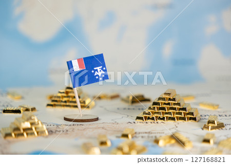 Miniature flag of French Southern and Antarctic Lands on a global map with numerous gold bars, symbolizing national resource wealth and economic strategic importance Miniature flag of French Southern and Antarctic Lands on a global map with numerous gold bars, symbolizing national resource wealth and economic strategic importance 127168821