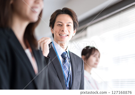 一位身穿西裝的年輕男子舉起拳頭 127168876